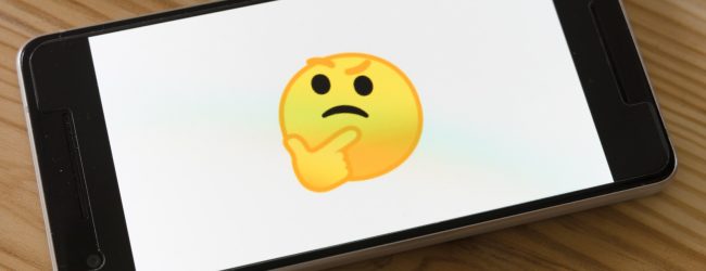 black flat screen tv turned on displaying yellow emoji